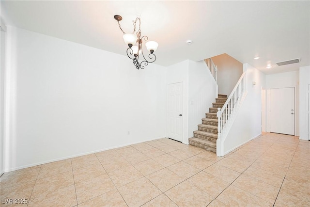 spare room with light tile patterned flooring and a chandelier