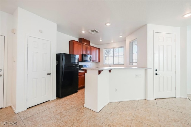 kitchen featuring a breakfast bar area, kitchen peninsula, light tile patterned floors, and black appliances