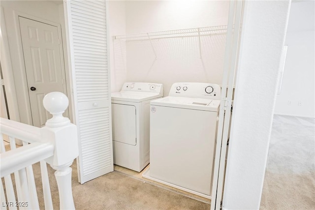 washroom with washer and dryer and light carpet