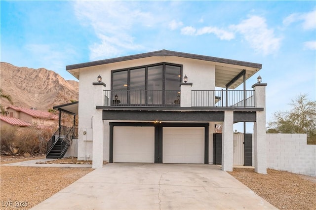 view of front facade featuring a balcony, a garage, and a mountain view