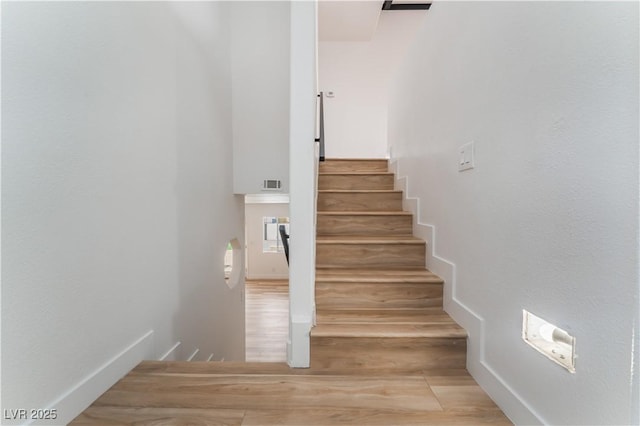 stairs featuring wood-type flooring