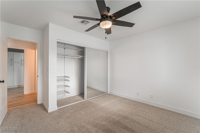 unfurnished bedroom featuring carpet flooring, ceiling fan, and a closet