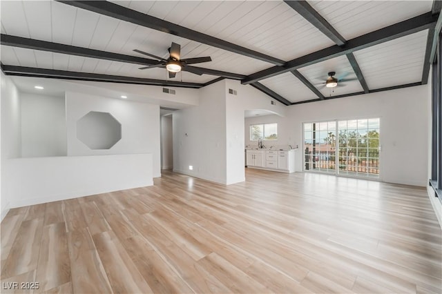 unfurnished living room with lofted ceiling with beams, sink, ceiling fan, and light hardwood / wood-style flooring