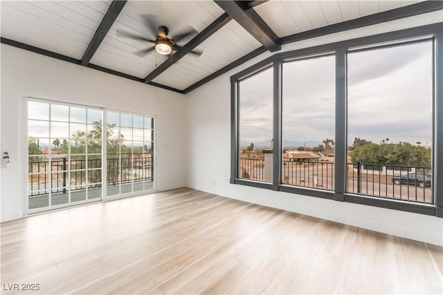 empty room featuring ceiling fan, vaulted ceiling with beams, and light hardwood / wood-style floors