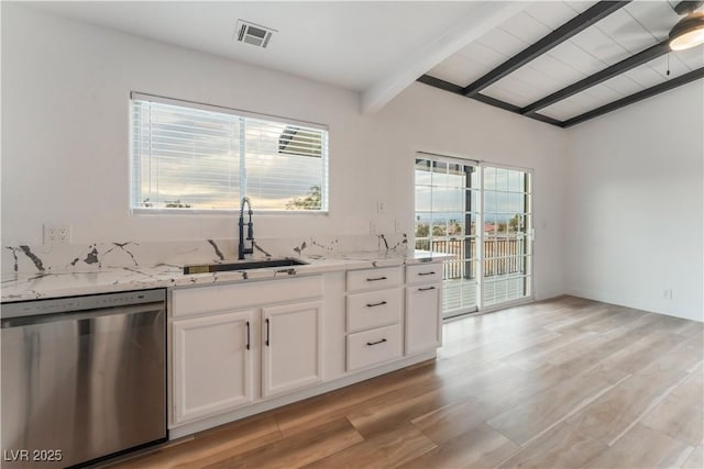 kitchen with sink, dishwasher, white cabinetry, vaulted ceiling with beams, and light stone countertops