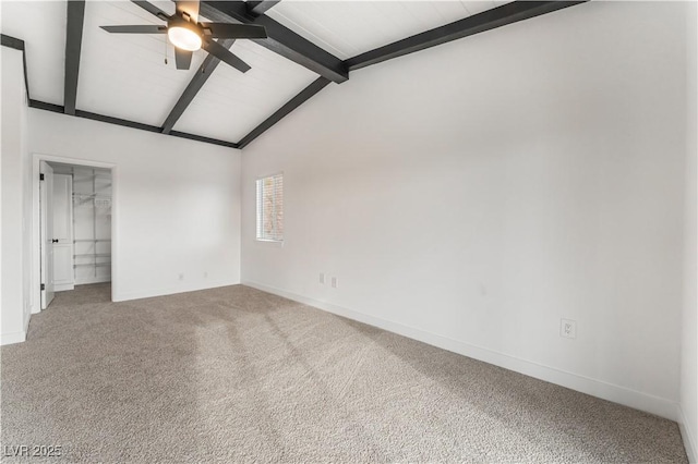 carpeted empty room with lofted ceiling with beams and ceiling fan