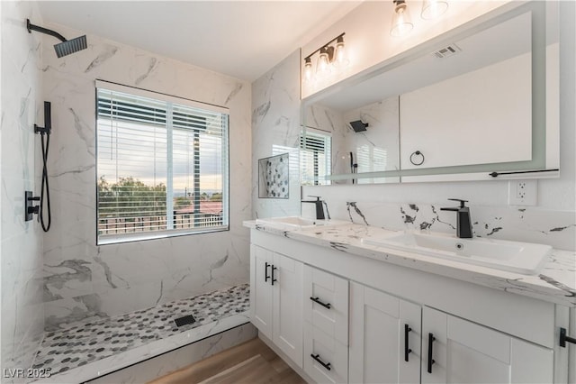 bathroom with vanity and tiled shower