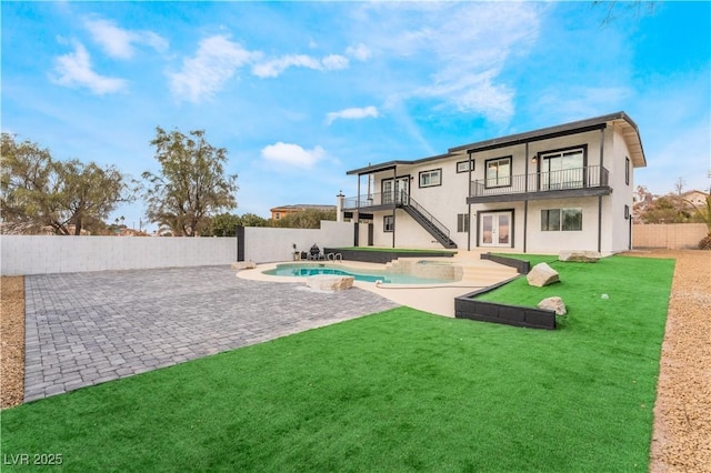 back of house featuring a fenced in pool, a balcony, a lawn, and a patio area