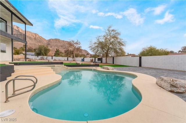 view of swimming pool with a mountain view and a patio