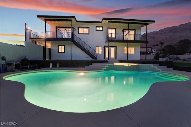 pool at dusk featuring a mountain view