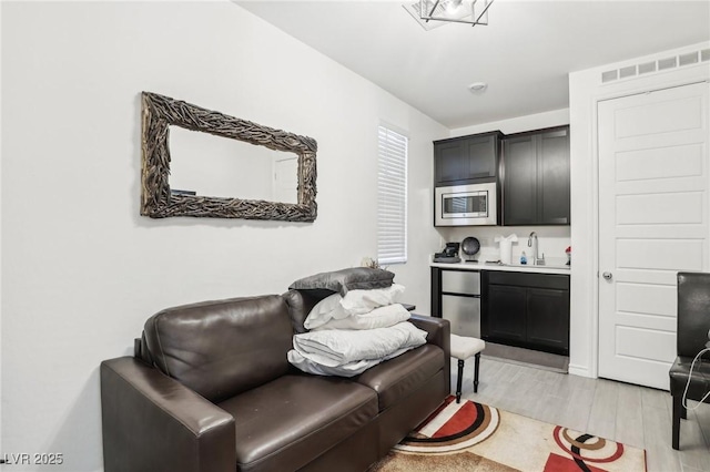 living room with sink and light wood-type flooring