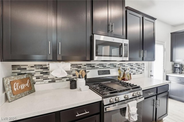 kitchen with tasteful backsplash, stainless steel appliances, light hardwood / wood-style floors, and dark brown cabinetry