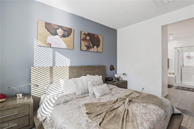 bedroom with hardwood / wood-style flooring and connected bathroom