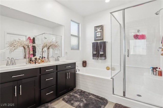 bathroom featuring vanity, wood-type flooring, and plus walk in shower