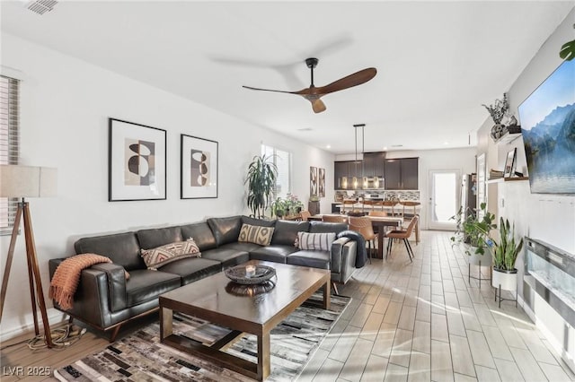 living room with ceiling fan and light hardwood / wood-style floors