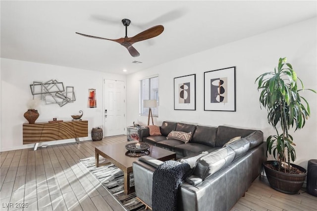 living room featuring hardwood / wood-style floors and ceiling fan