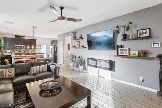 living room featuring ceiling fan and wood-type flooring