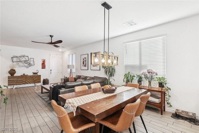 dining space with ceiling fan and light wood-type flooring