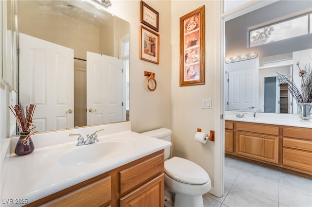 bathroom with toilet, tile patterned floors, and vanity