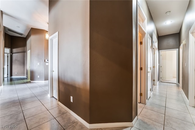 hall with light tile patterned flooring and baseboards