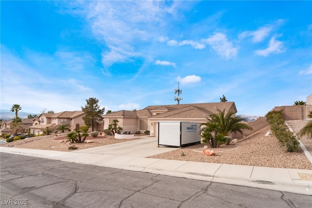 view of front facade with a residential view, concrete driveway, and an attached garage