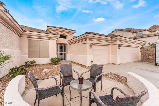 view of patio featuring a garage and concrete driveway