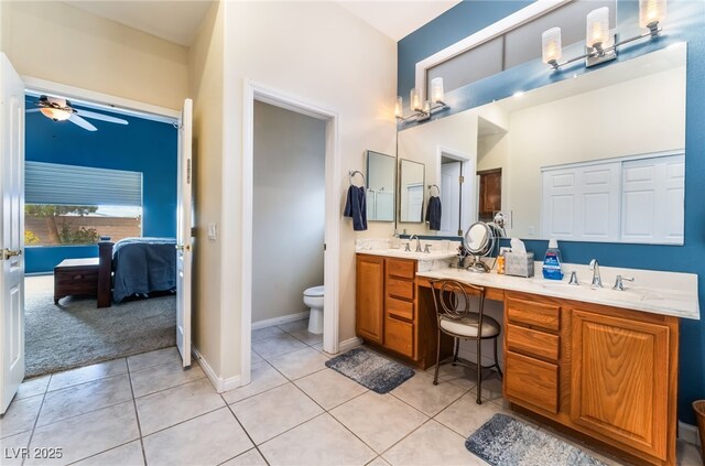 ensuite bathroom with double vanity, toilet, ceiling fan, ensuite bath, and tile patterned flooring