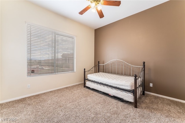 carpeted bedroom with ceiling fan and baseboards