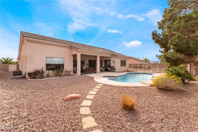 view of swimming pool with a fenced backyard, a pool with connected hot tub, central AC, and a patio