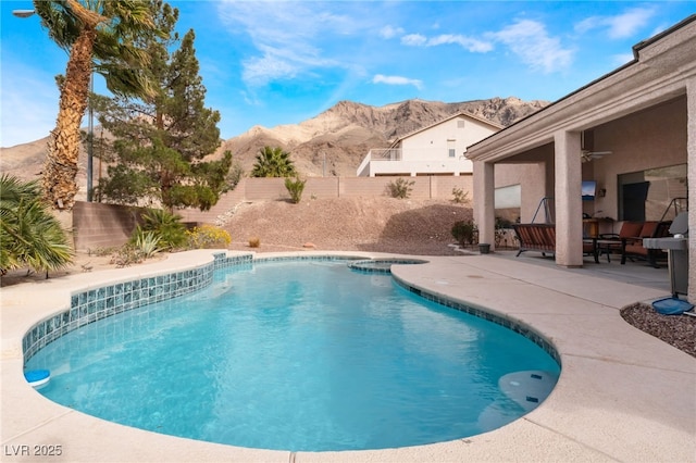 view of pool featuring a patio area, a fenced backyard, a mountain view, and ceiling fan