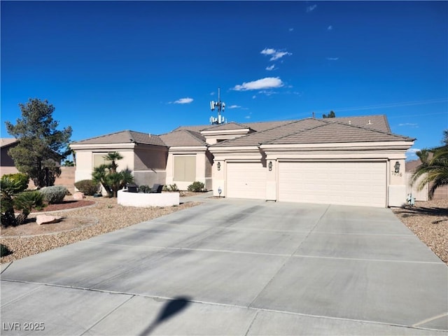 view of front of house featuring a garage, concrete driveway, a tiled roof, and stucco siding