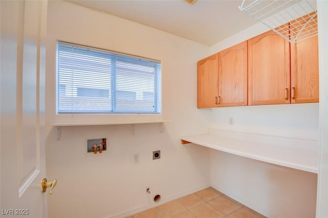 washroom with electric dryer hookup, washer hookup, light tile patterned floors, and cabinets