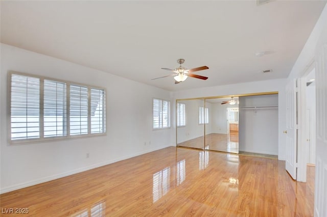 unfurnished bedroom with ceiling fan, light wood-type flooring, and a closet