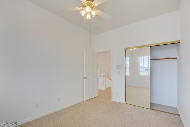 unfurnished bedroom with light carpet, ceiling fan, and a closet