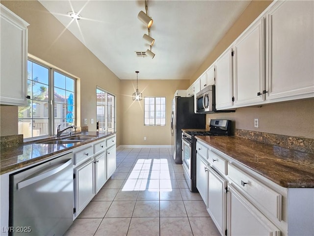 kitchen featuring light tile patterned floors, visible vents, appliances with stainless steel finishes, white cabinets, and a sink