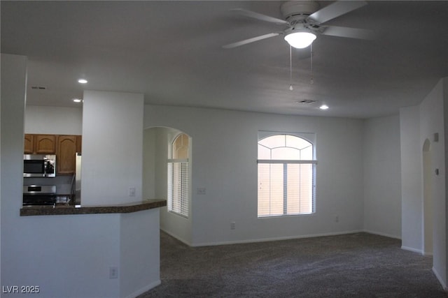 carpeted spare room with ceiling fan