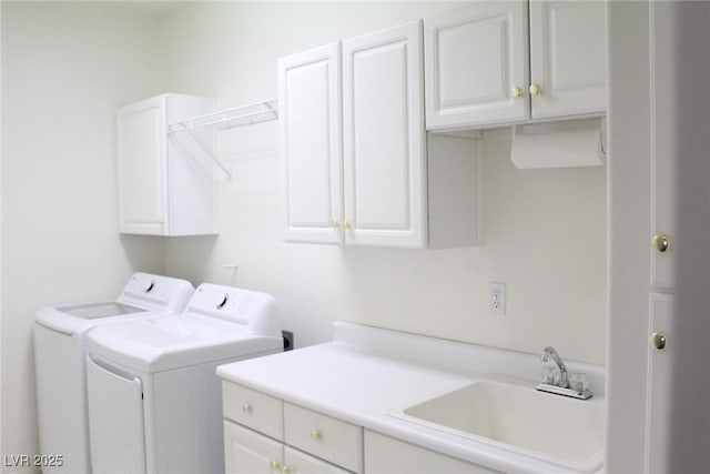 clothes washing area featuring cabinets, washer and dryer, and sink