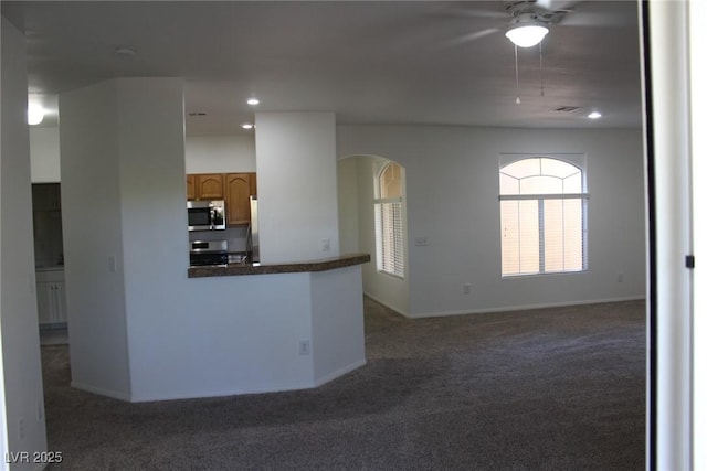 kitchen with stainless steel appliances, kitchen peninsula, and dark colored carpet