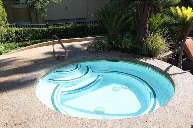 view of swimming pool with an in ground hot tub