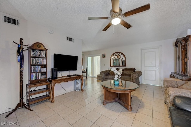 living room featuring a textured ceiling, ceiling fan, and light tile patterned flooring