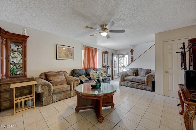 living room with light tile patterned floors, a textured ceiling, and ceiling fan