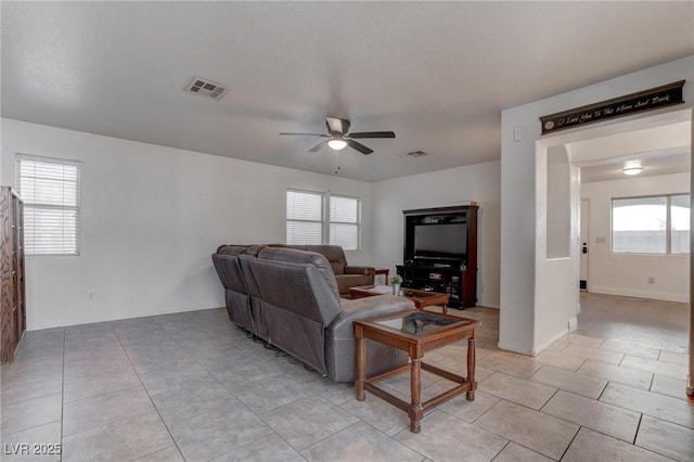 living area with a ceiling fan, light tile patterned floors, visible vents, and a wealth of natural light