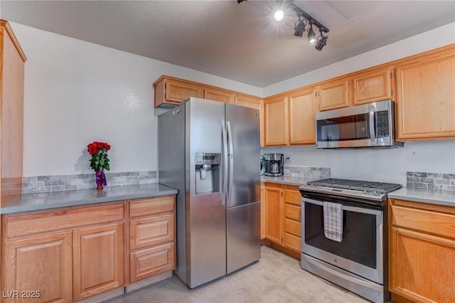 kitchen with appliances with stainless steel finishes, light countertops, and tasteful backsplash