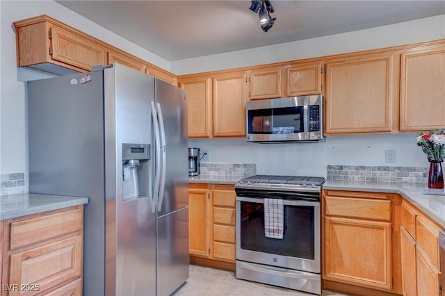 kitchen with backsplash, appliances with stainless steel finishes, and light brown cabinets