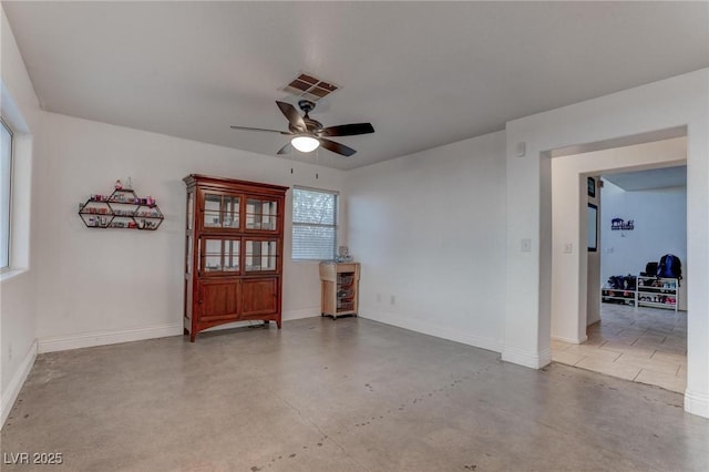 empty room with visible vents, concrete floors, baseboards, and ceiling fan