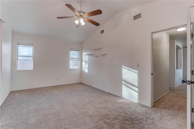 spare room with light carpet, ceiling fan, visible vents, and vaulted ceiling