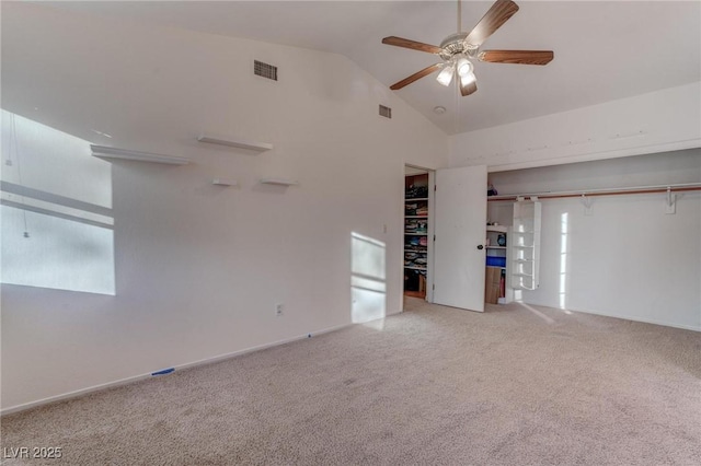 carpeted empty room featuring ceiling fan, high vaulted ceiling, and visible vents