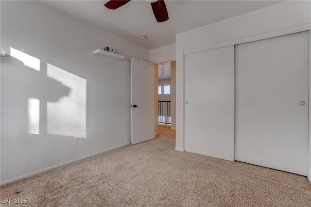 unfurnished bedroom with light colored carpet, a closet, and ceiling fan