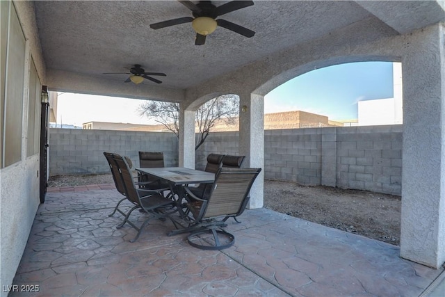 view of patio / terrace featuring outdoor dining area, a fenced backyard, and a ceiling fan