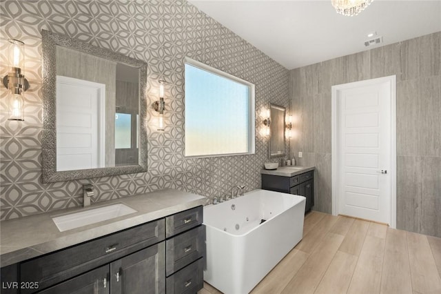 bathroom with vanity, wood-type flooring, and a bath